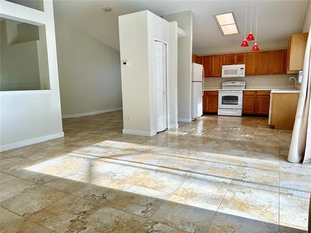 a view of a kitchen with wooden floor and electronic appliances