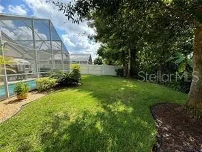 a view of green field with trees in the background