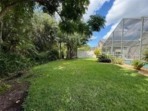 an aerial view of residential house with outdoor space and trees all around