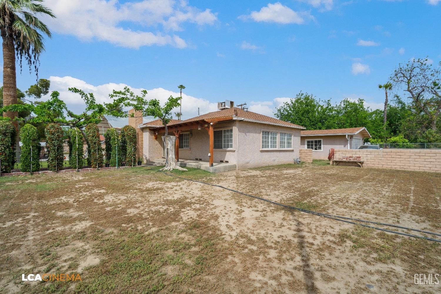Undisclosed Address Bakersfield, CA 93307 - Photo 2 of 18 a backyard of a house with lots of green space