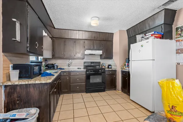 a kitchen with a refrigerator and a stove top oven
