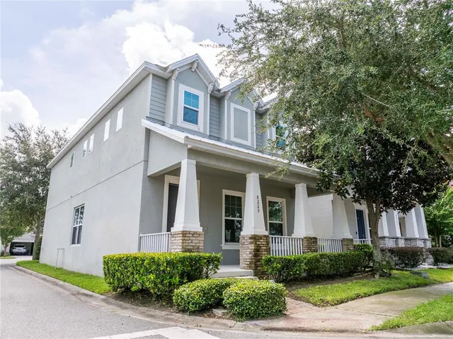 a front view of a house with a yard and potted plants
