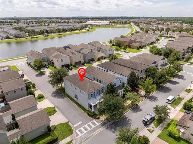 an aerial view of residential houses with outdoor space and lake view