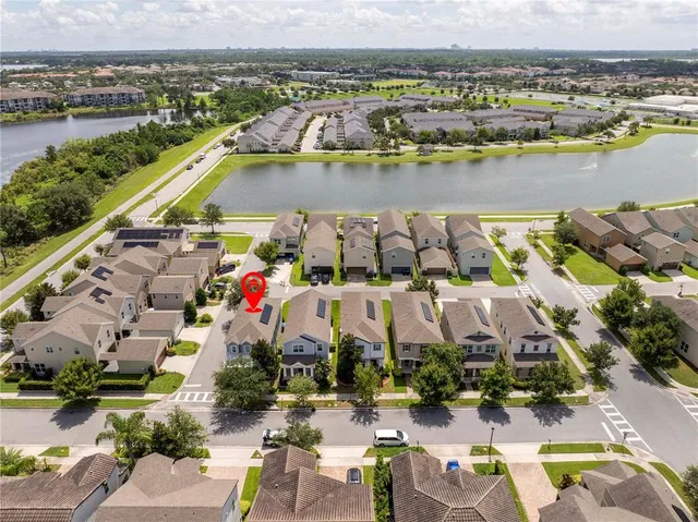 an aerial view of residential houses with outdoor space and ocean view