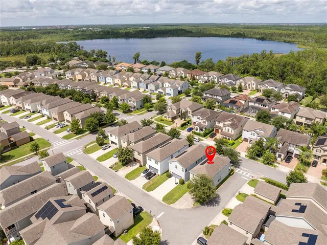 an aerial view of a house with a garden and lake view