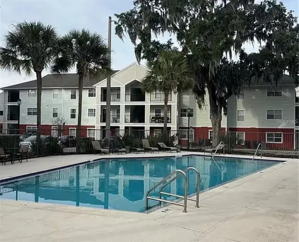a view of a swimming pool with a patio and a yard