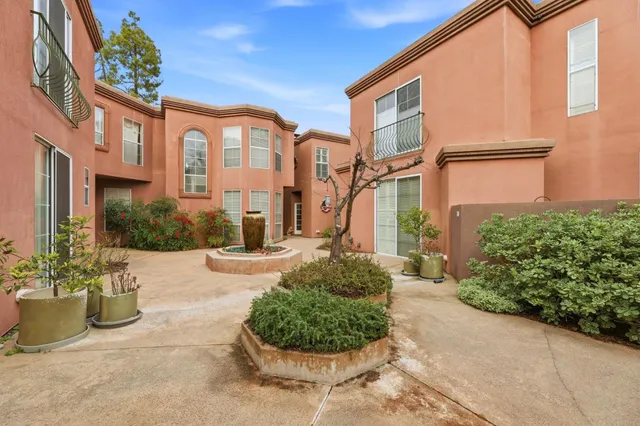 a living room with furniture kitchen view and a wooden floor