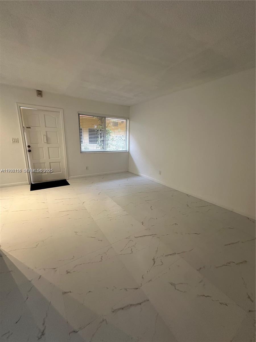 1733 Mayo Street, Unit 2 Hollywood, FL 33020 - Photo 7 of 10 an empty room with windows and fireplace