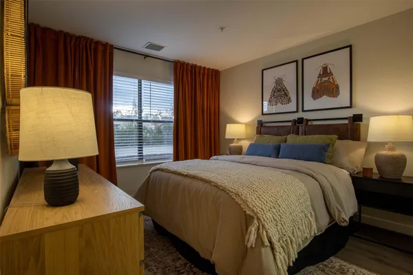 a bedroom with a bed and dresser with mirror