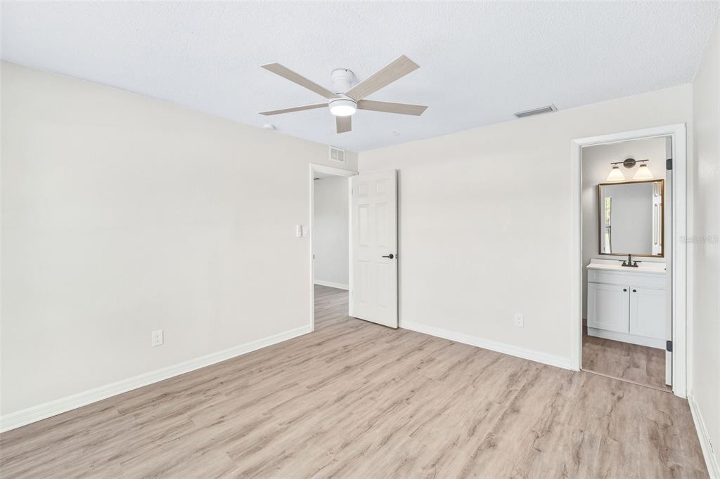 4320 Carousel Road Orlando, FL 32808 - Photo 13 of 18 an empty room with wooden floor and a ceiling fan