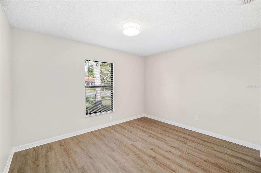 4320 Carousel Road Orlando, FL 32808 - Photo 14 of 18 an empty room with wooden floor and windows
