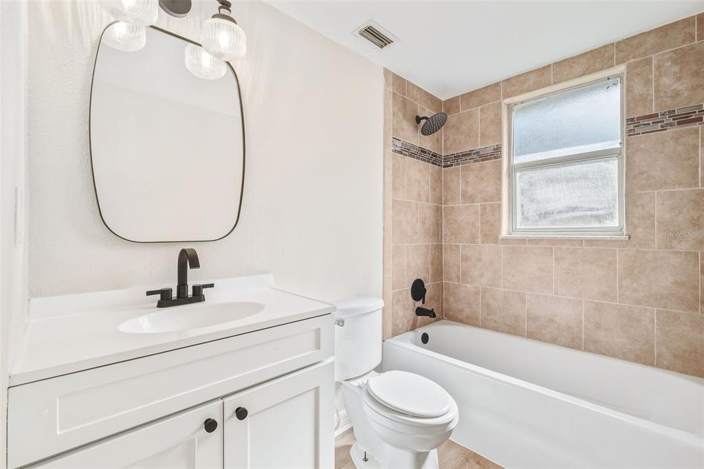 4320 Carousel Road Orlando, FL 32808 - Photo 15 of 18 a bathroom with a sink a mirror a toilet and bathtub