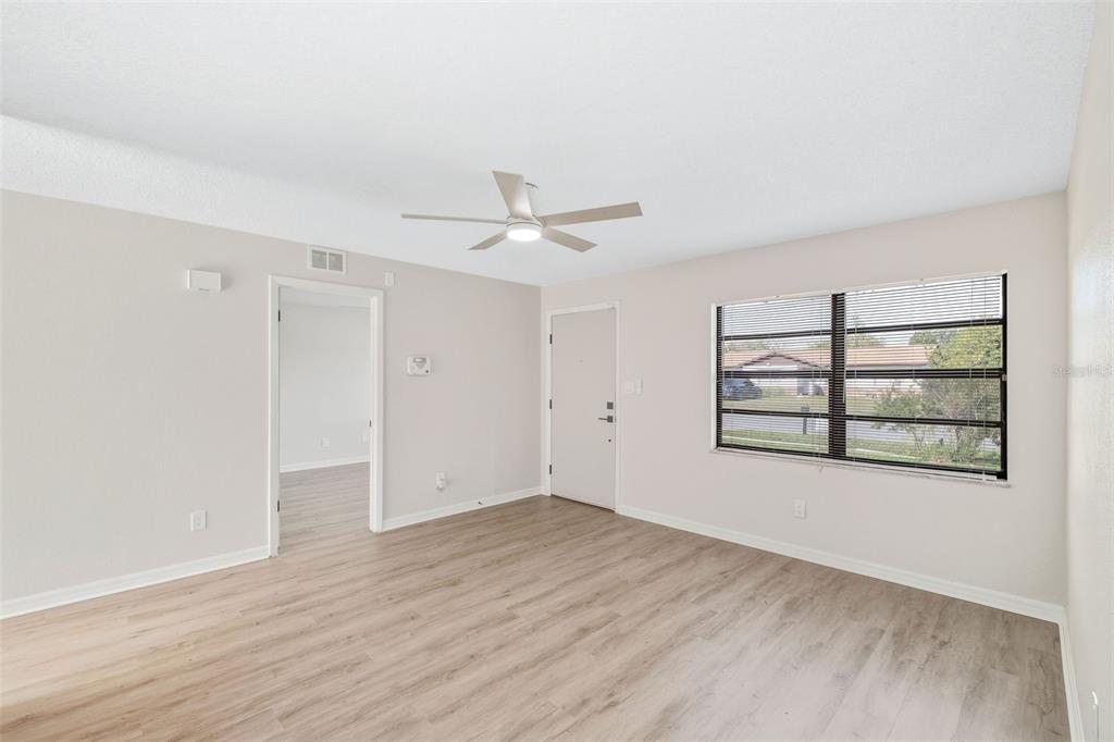 4320 Carousel Road Orlando, FL 32808 - Photo 3 of 18 wooden floor in an empty room with a window