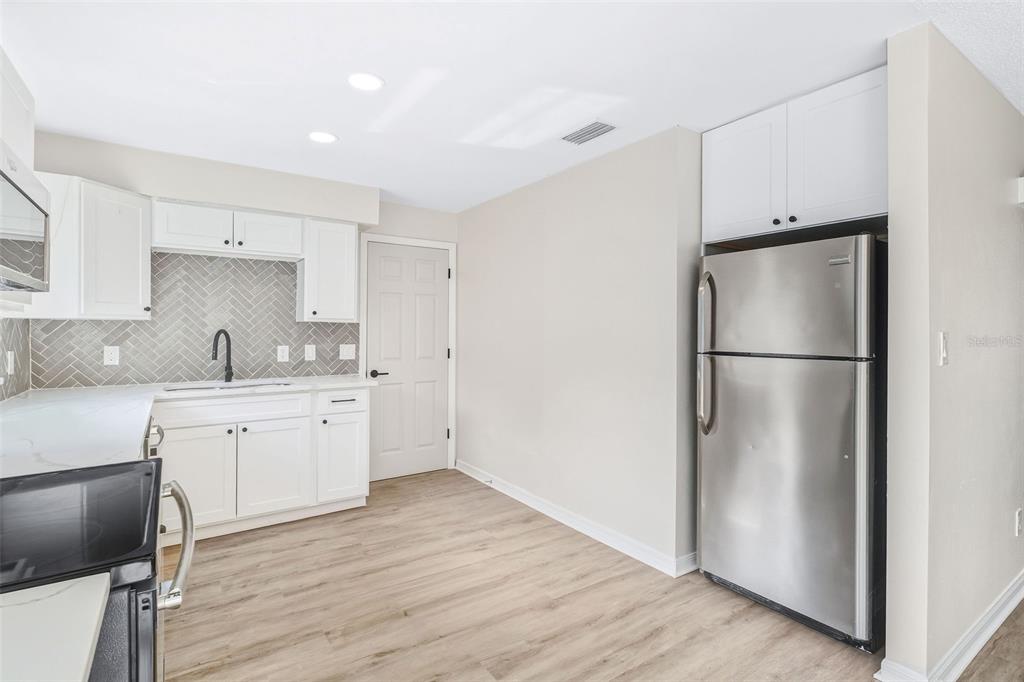 4320 Carousel Road Orlando, FL 32808 - Photo 4 of 18 a kitchen with refrigerator cabinets and wooden floor