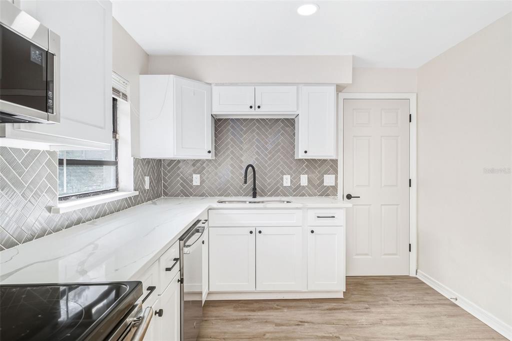 4320 Carousel Road Orlando, FL 32808 - Photo 7 of 18 a kitchen with a sink stove and microwave