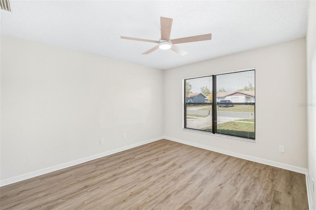 4320 Carousel Road Orlando, FL 32808 - Photo 8 of 18 an empty room with wooden floor and windows