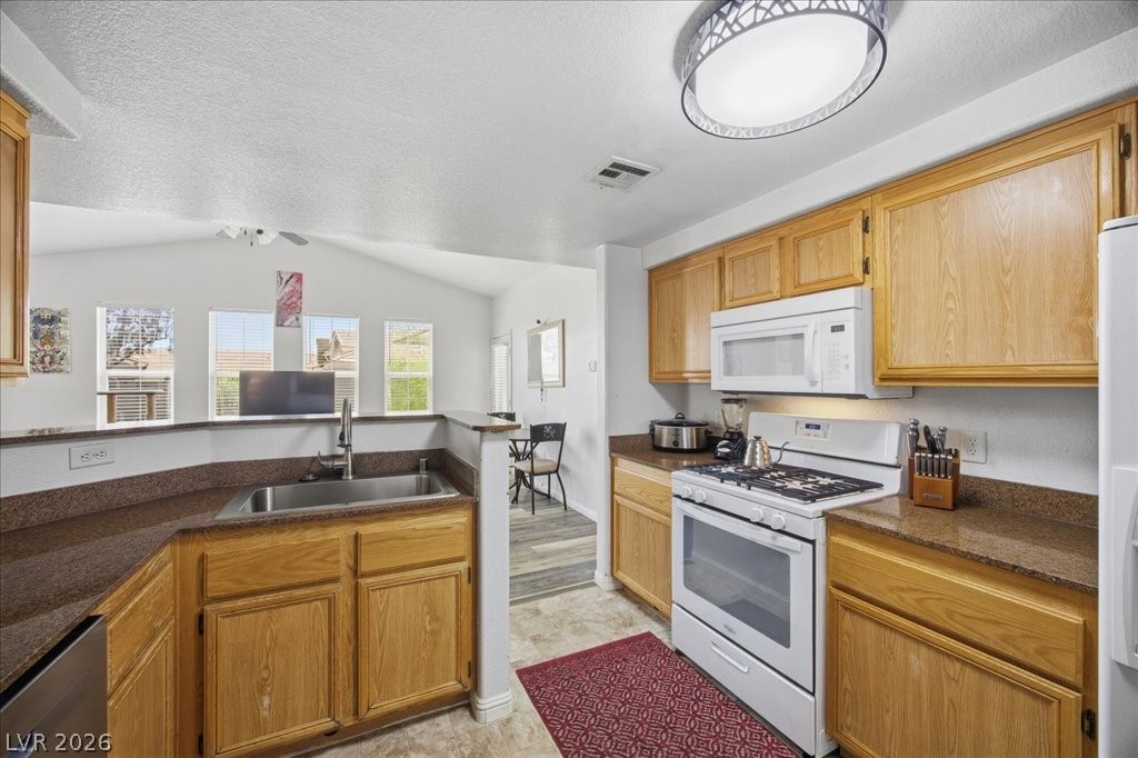 10550 West Alexander Road, Unit 2164 Las Vegas, NV 89129 - Photo 11 of 27 A well-equipped kitchen features ample cabinetry, a dedicated dining area, and a bright, open feel.