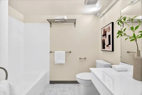 a bathroom with a sink a toilet and shower