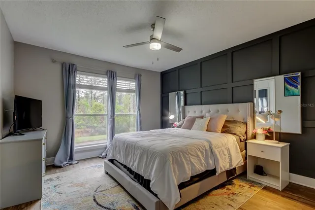 a bedroom with a bed tv and a window