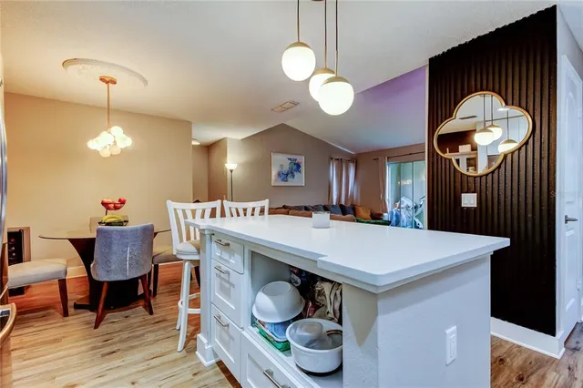 a kitchen with a table a sink cabinets and stainless steel appliances