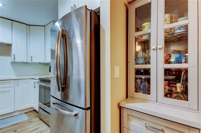 a kitchen with stainless steel appliances a refrigerator a stove a sink dishwasher and a dining table with wooden floor