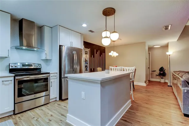a kitchen with stainless steel appliances a stove refrigerator and microwave