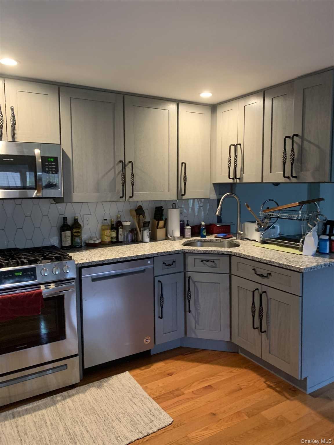 322 Sunset Hill Road East, Unit 2 Fishkill, NY 12524 - Photo 3 of 13 a kitchen with stainless steel appliances granite countertop a stove a sink and a microwave