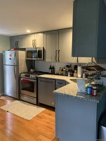 a kitchen with stainless steel appliances granite countertop a refrigerator sink and stove