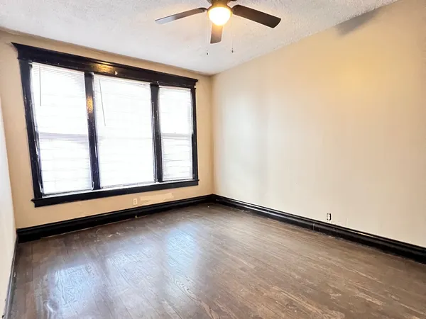 a bedroom with a bed and a large window