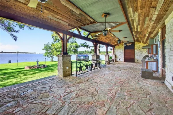 a view of a backyard with table and chairs under an umbrella