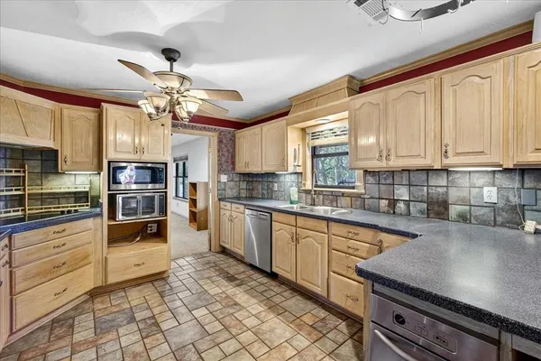 a kitchen with stainless steel appliances granite countertop a stove refrigerator and cabinets