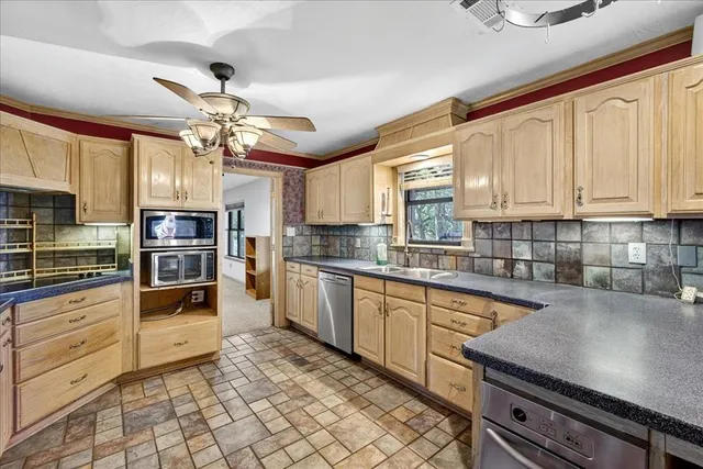 a kitchen with stainless steel appliances granite countertop a stove refrigerator and cabinets