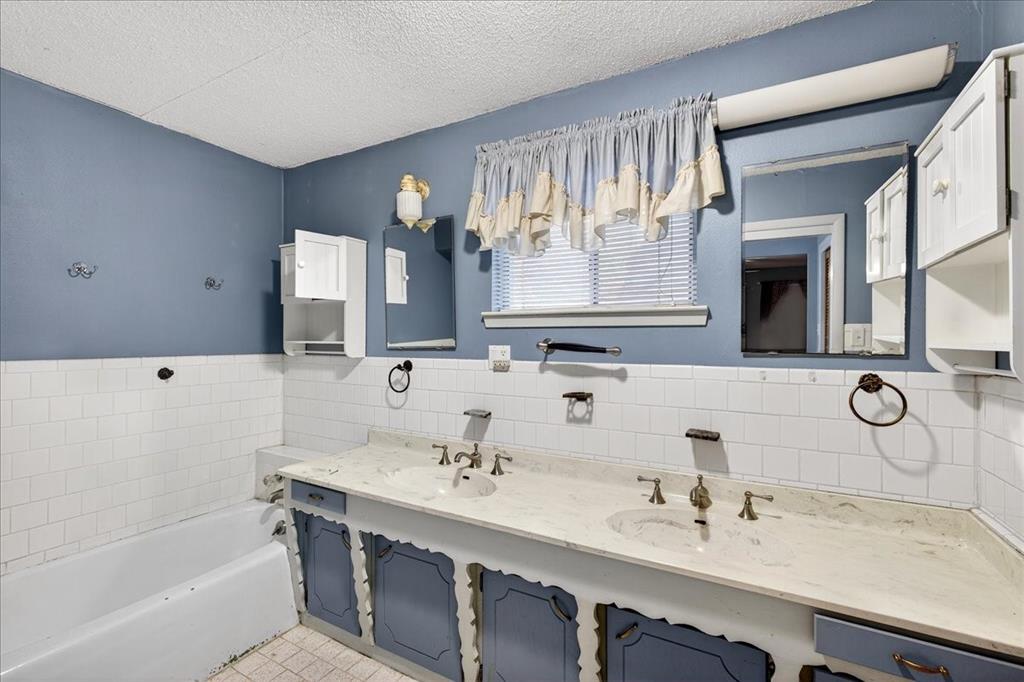 6903 Scott Street Eustace, TX 75124 - Photo 21 of 32 a bathroom with a double vanity sink mirror and bathtub