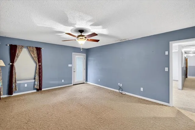 an empty room with a ceiling fan and a window