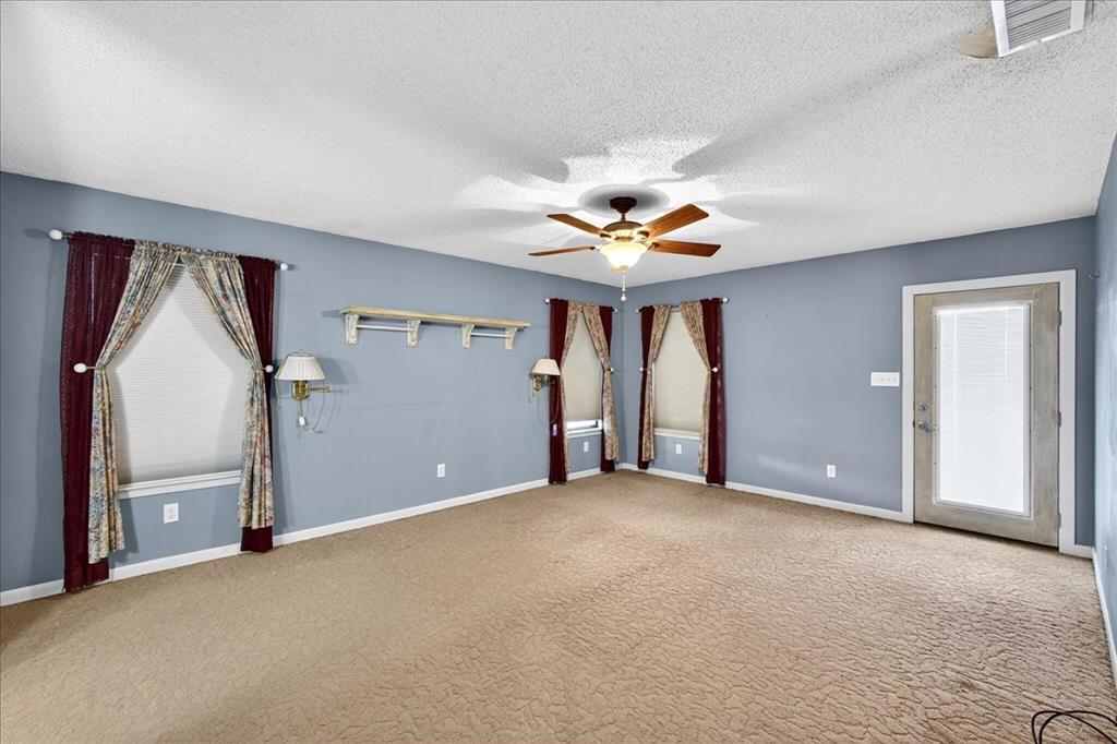 6903 Scott Street Eustace, TX 75124 - Photo 32 of 32 an empty room with chandelier fan and windows