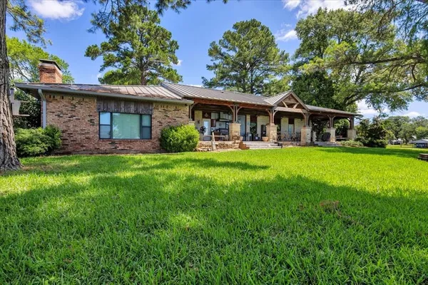 a front view of a house with a yard and trees