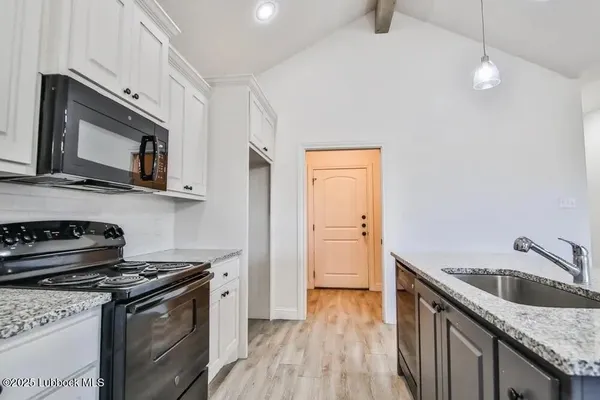 a kitchen with a stove microwave and sink