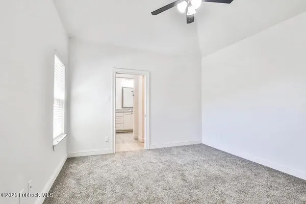 an empty room with a chandelier fan