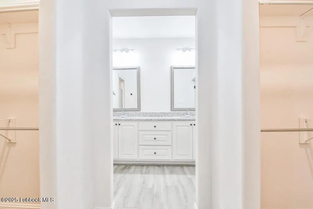 1602 102nd Street Lubbock, TX 79423 - Photo 7 of 16 a bathroom with a sink vanity and a mirror