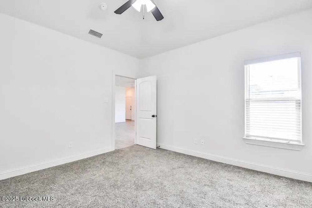 1602 102nd Street Lubbock, TX 79423 - Photo 9 of 16 an empty room with a empty space and a ceiling fan