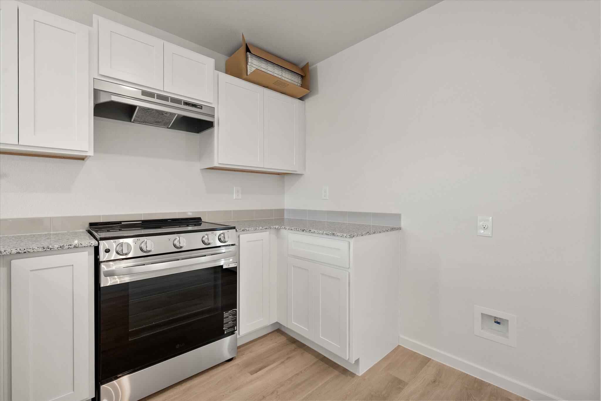 8312 25th Street Lubbock, TX 79407 - Photo 10 of 17 a kitchen with granite countertop white cabinets and white appliances