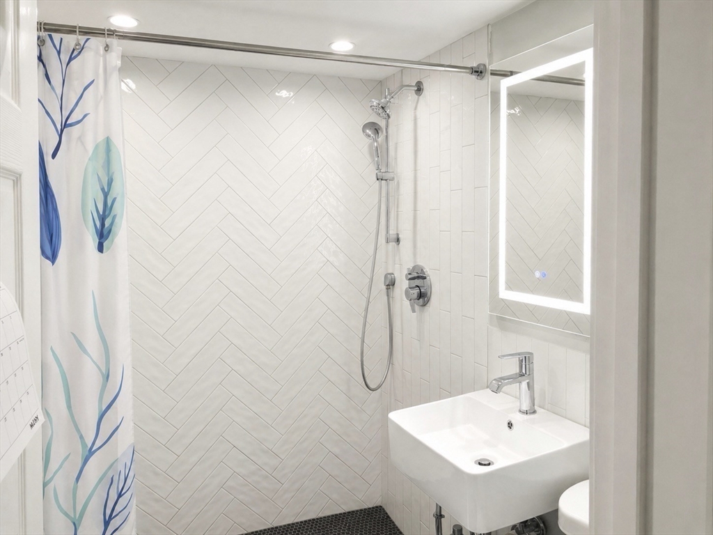147 Winthrop Road, Unit 2 Brookline, MA 02445 - Photo 6 of 19 a bathroom with a shower curtain and a sink