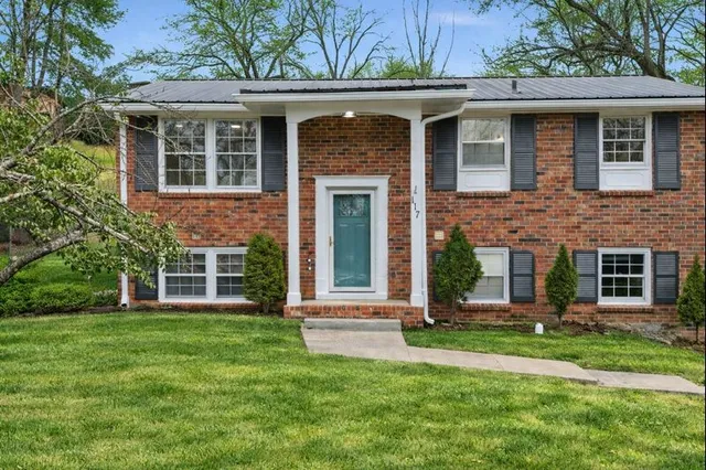 front view of a brick house with a yard