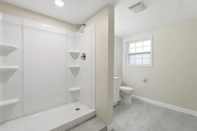 a bathroom with a toilet a sink and shower