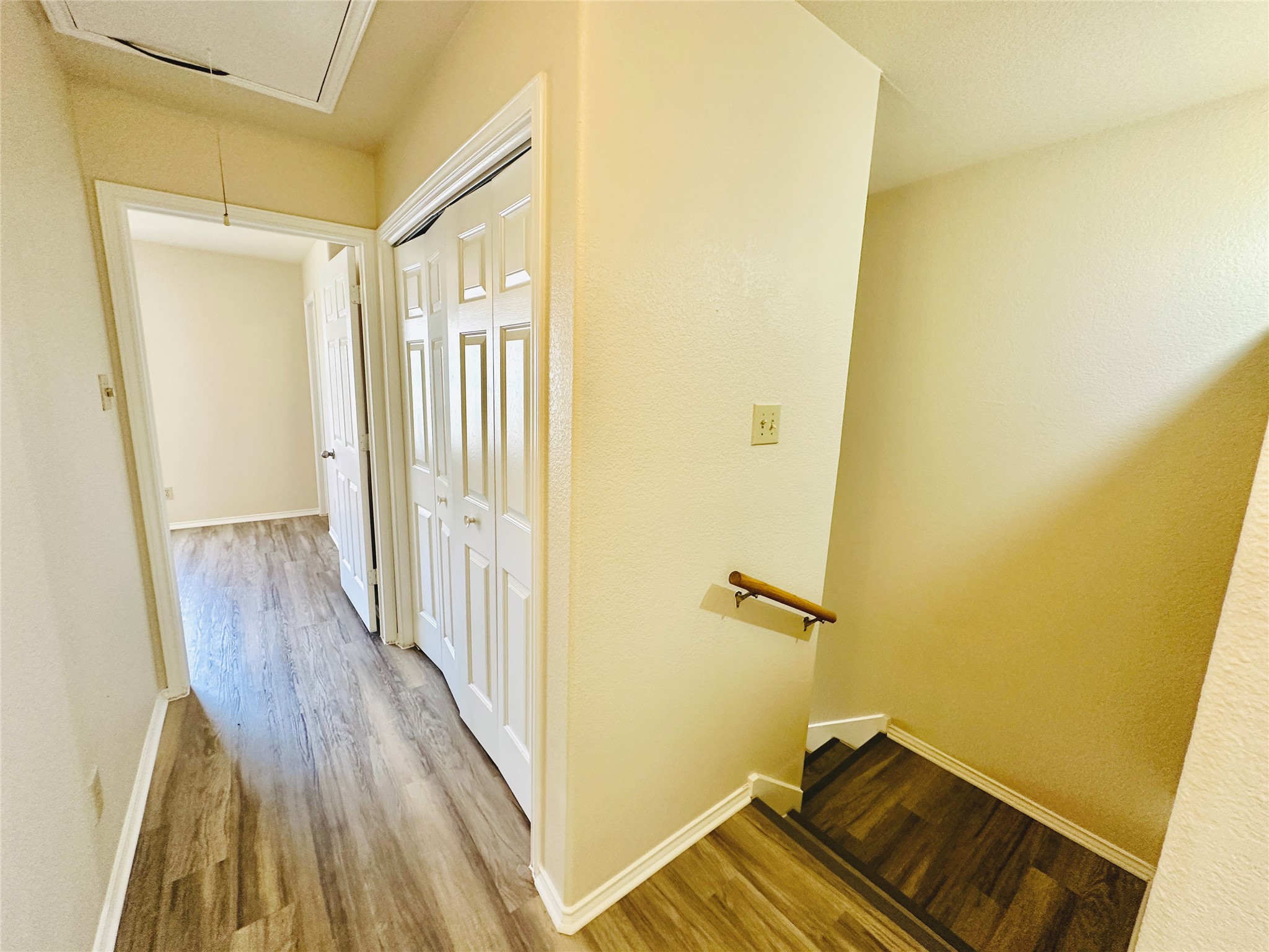 8814 Schick Road, Unit C Austin, TX 78729 - Photo 21 of 35 Functional hallway with wood-look flooring leads to rooms and a stairway.