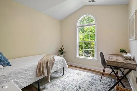 a bed sitting in a bedroom next to a window
