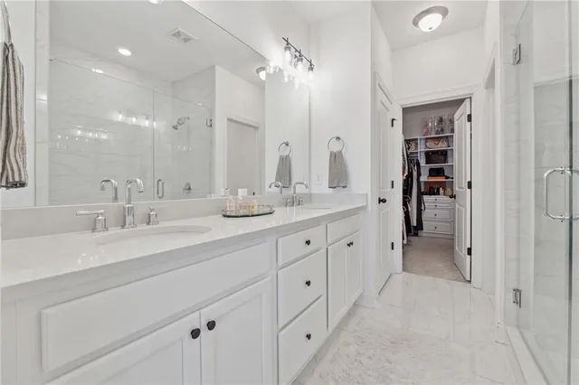 a spacious en suite bathroom with double sink and a large mirror