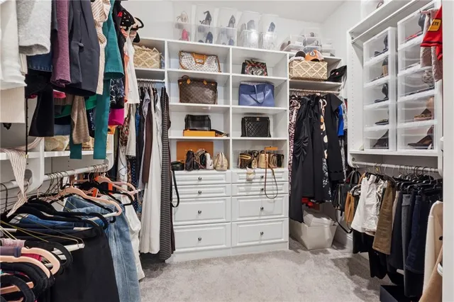 a view of walk in closet with clothes and shoes