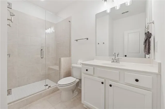 a bathroom with a toilet a sink a mirror and a shower