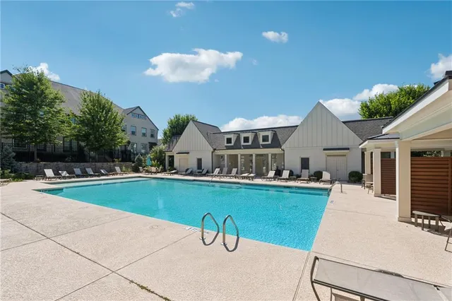a view of a house with pool backyard and sitting area